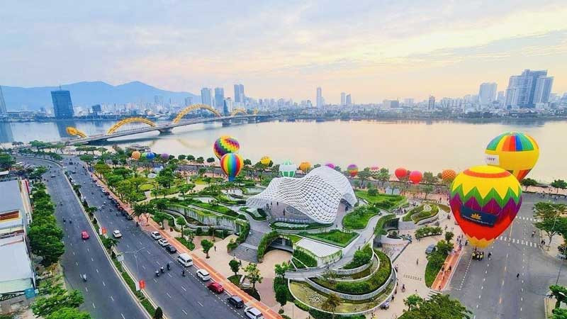 Đường phố Đà Nẵng với hàng cây xanh và xe cộ, thể hiện sự thoáng đãng của thành phố.