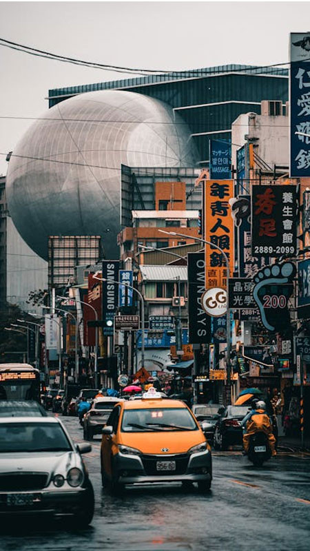 Đường phố tấp nập với xe cộ và con người trong ảnh đường phố cổ điển, thể hiện không khí thập niên 80 90.