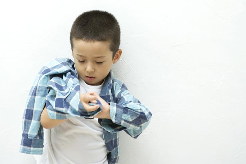 Em bé đang tự mặc quần, biểu thị kỹ năng tự mặc quần áo.