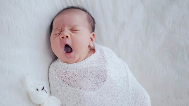 Em bé ngủ gật trong tư thế đầu gục xuống đáng yêu