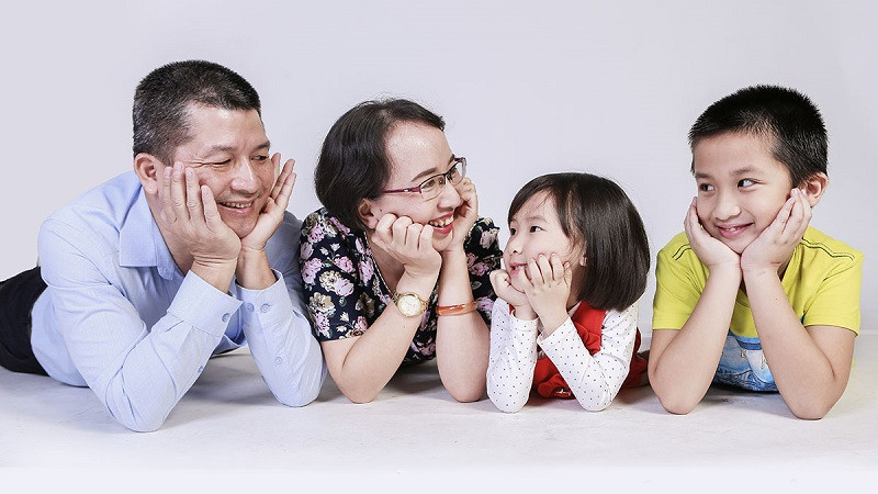 Gia đình 4 người cùng nhau cười lớn, thể hiện sự vui vẻ