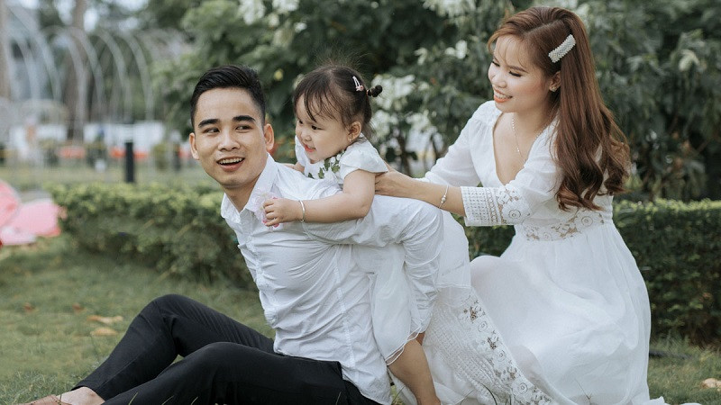 Gia đình 4 người mặc đồ màu be và trắng, chụp ảnh rất tự nhiên