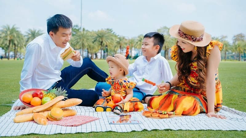 Gia đình 4 người mặc đồ thoải mái, đang vui đùa trên giường