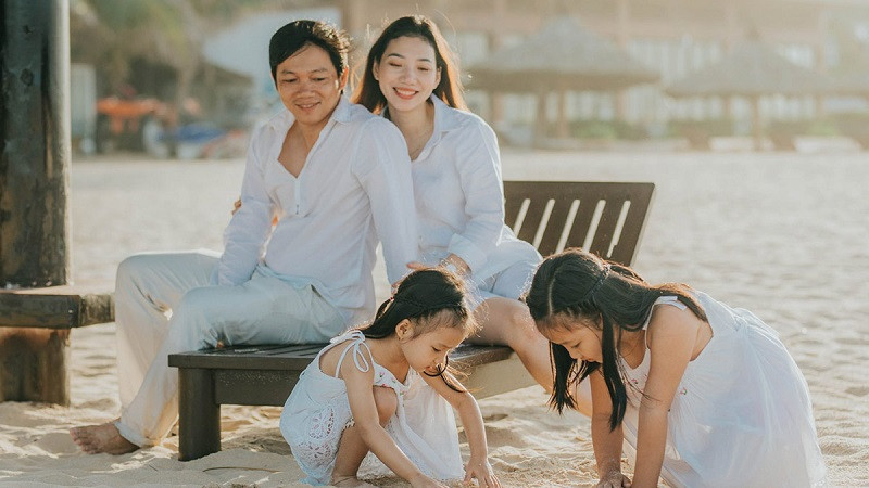 Gia đình 4 người mặc đồ trắng, ngồi sát vào nhau đầy ấm cúng