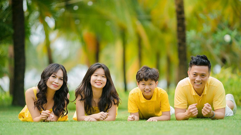 Gia đình 4 người ngồi trên ghế sofa lớn, cười rạng rỡ