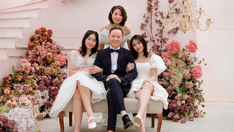 Gia đình 4 người ngồi trên sàn gỗ, nhìn về một hướng, đầy hy vọng