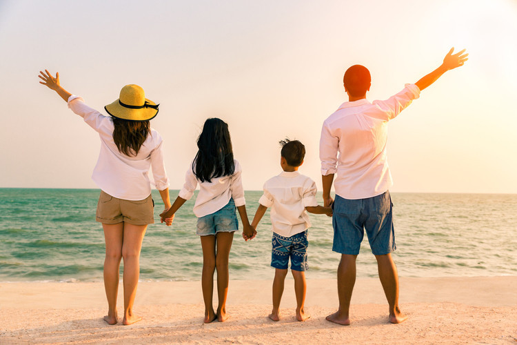 Gia đình hạnh phúc đi du lịch và chụp ảnh tại bãi biển