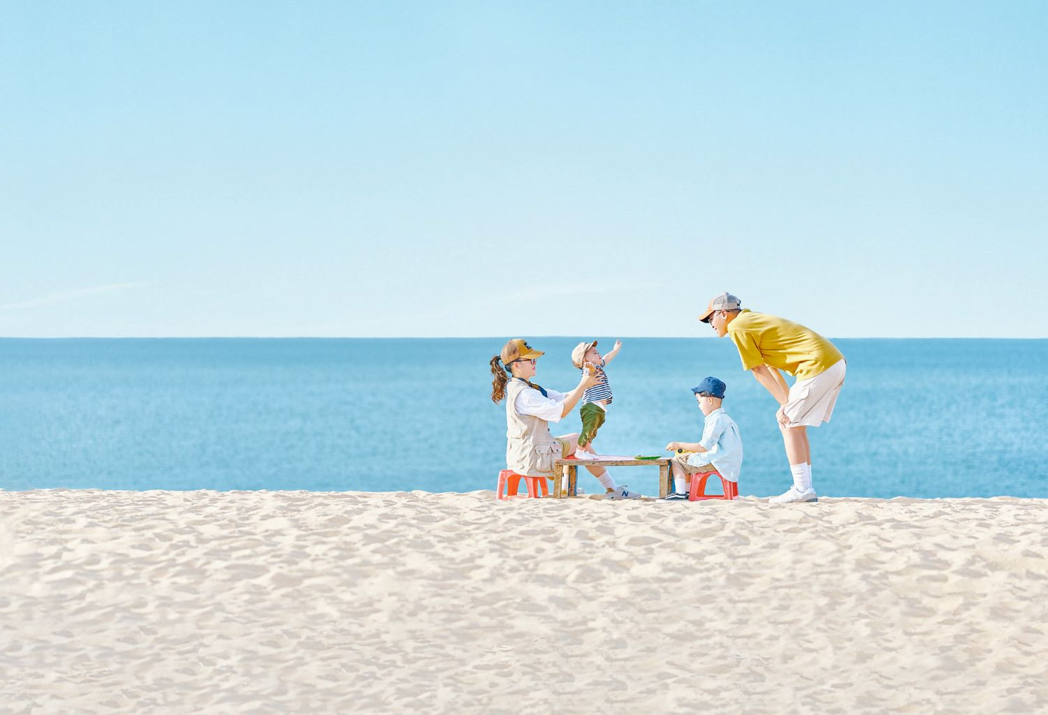 Gia đình hạnh phúc tạo dáng chụp ảnh bên bờ biển thơ mộng