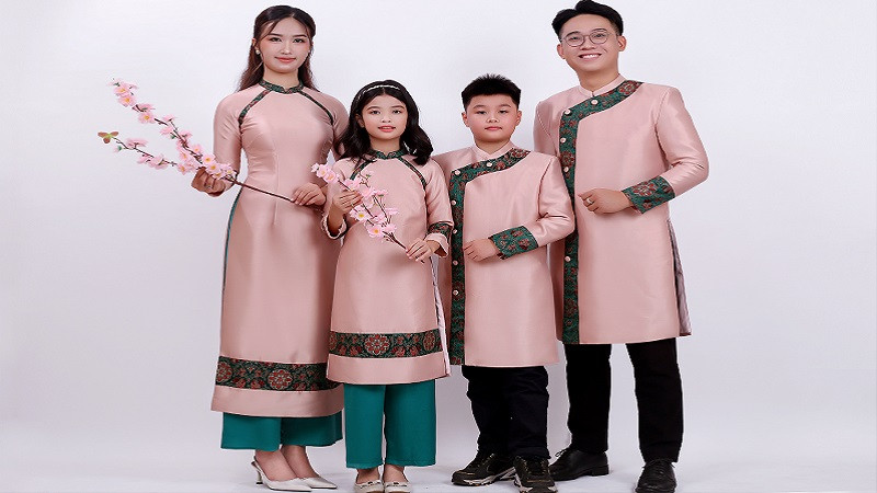 Gia đình mặc áo dài đỏ, chụp ảnh Tết bên câu đối đỏ