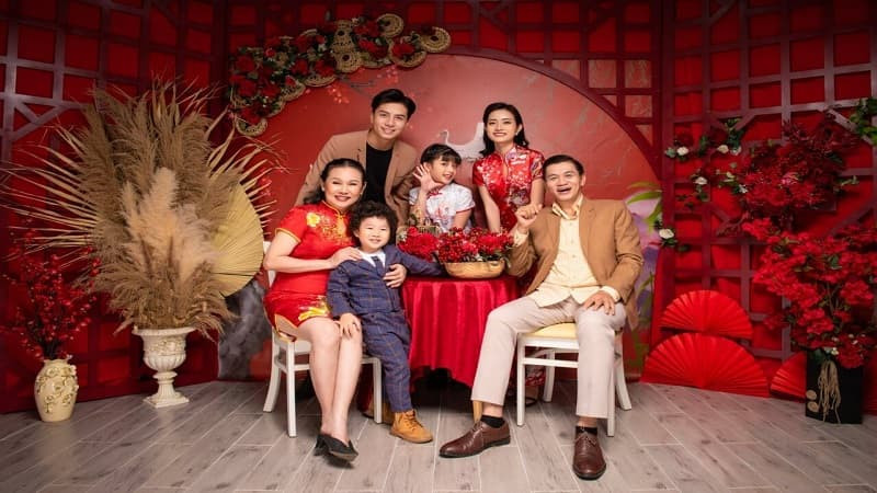 Gia đình mặc áo dài đỏ, chụp ảnh Tết bên cây đào, đầy không khí xuân