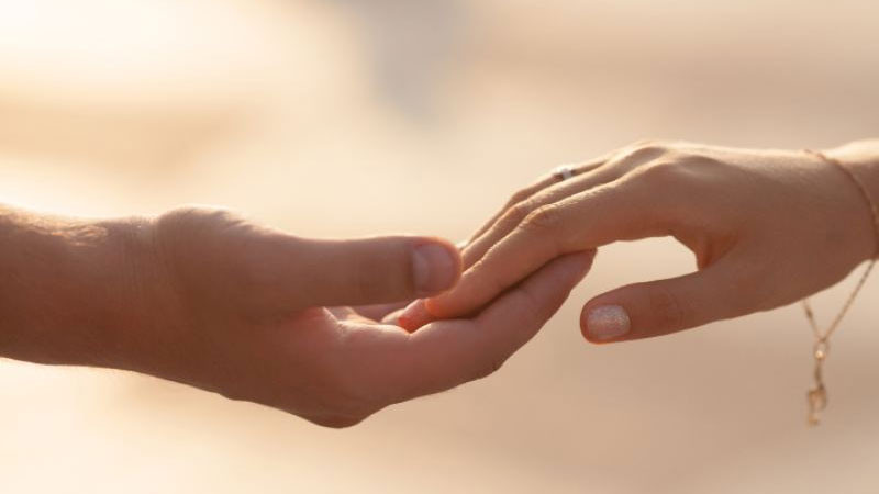 Góc chụp cận cảnh đôi bàn tay nắm chặt trên nền màu xám