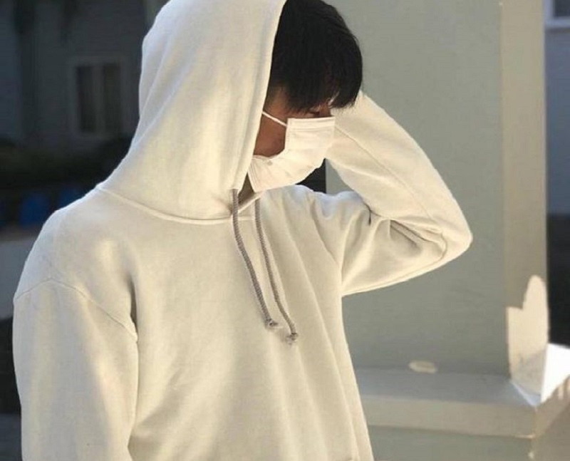 Góc chụp nghiêng của chàng trai đeo khẩu trang trắng che mặt