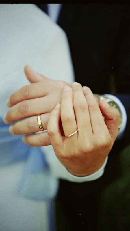 Góc chụp từ trên cao xuống đôi bàn tay nắm nhau với nhẫn nổi bật