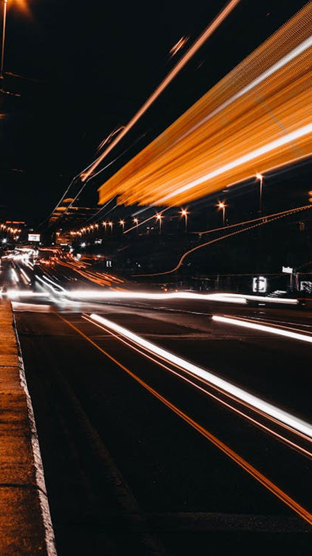 Góc đường phố về đêm với cửa hàng sáng đèn, mang đến vẻ ấm áp trong không gian tĩnh lặng của ảnh đường phố.