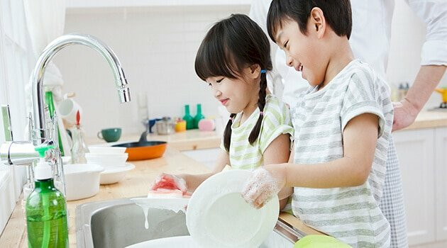 Hai chị em vui vẻ cùng nhau rửa bát sau bữa cơm gia đình