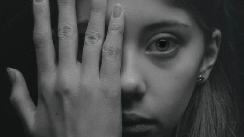 Hình ảnh bàn tay che mặt, thể hiện sự che giấu cảm xúc và nỗi buồn