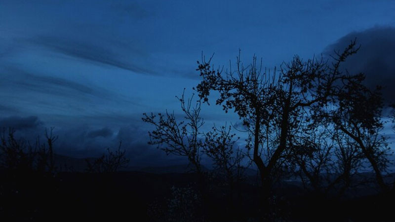 Hình ảnh bầu trời đêm tối với vài đám mây và ánh sáng mờ