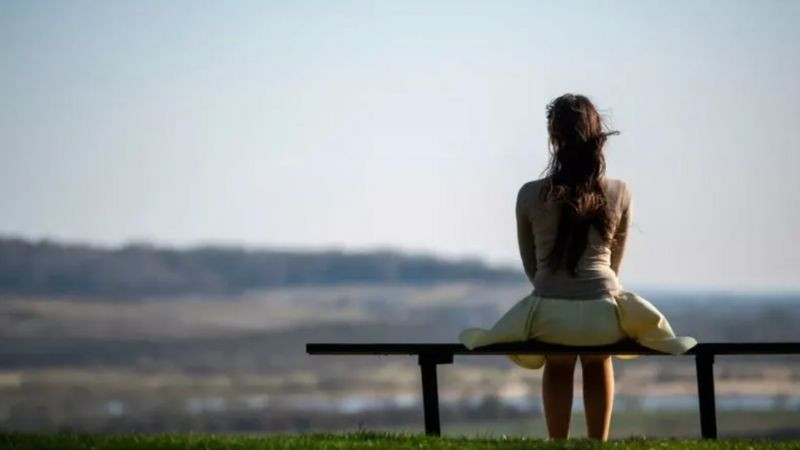 Hình ảnh cô đơn một cô gái ngồi một mình trong phòng với ánh sáng mờ