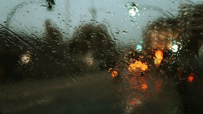 Hình ảnh cô đơn nhìn qua cửa kính ướt đẫm khi trời mưa