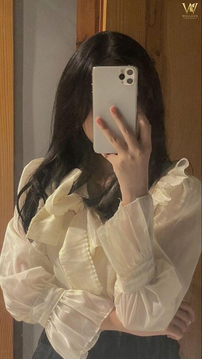 Hình ảnh cô gái dùng điện thoại che mặt khi selfie