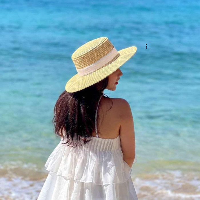 Hình ảnh cô gái xinh đẹp đội mũ cói đứng bên bờ biển