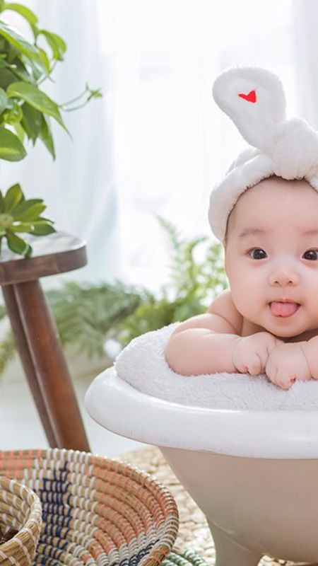 Hình ảnh em bé đội mũ giữa cánh đồng hoa