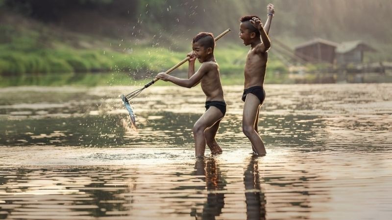 Hình ảnh hồn nhiên của hai đứa trẻ bắt cá