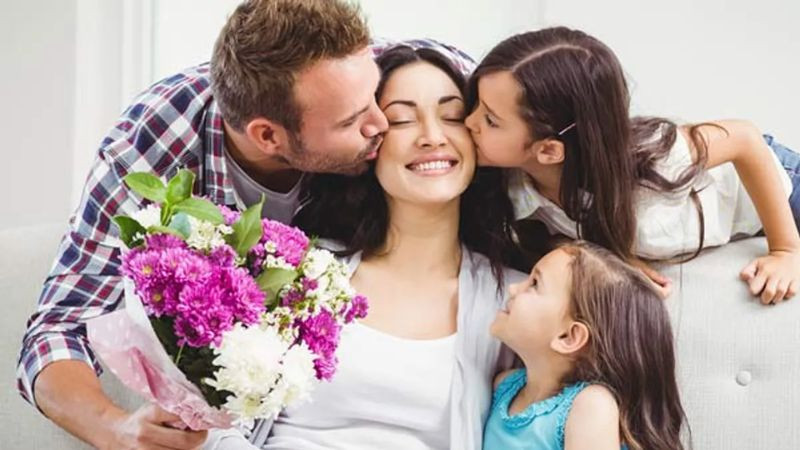 Hình ảnh mẹ mỉm cười rạng rỡ bên bó hoa, một trong những ảnh đẹp về mẹ tràn đầy sức sống.