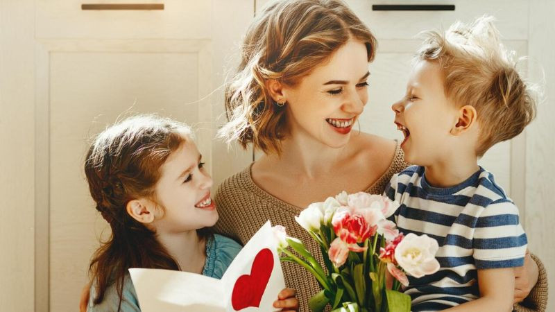 Hình ảnh mẹ và con gái nắm tay nhau đi dạo trong khung cảnh lãng mạn, thể hiện tình thân yêu gắn bó.