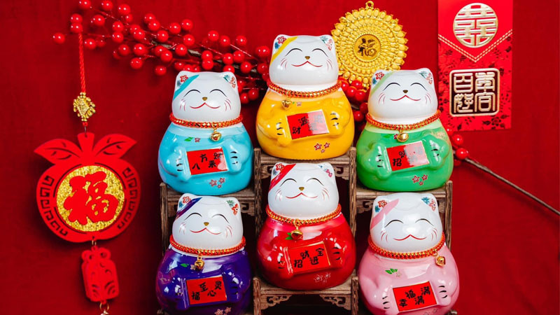 Hình ảnh mèo thần tài màu vàng đang vẫy tay, biểu tượng của sự thịnh vượng và may mắn