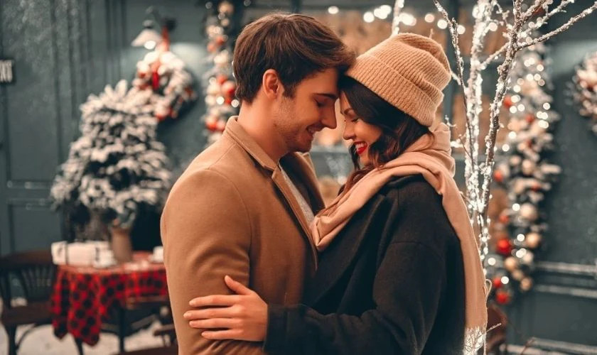 Hình ảnh một cặp đôi đang ngồi bên nhau và thưởng thức đồ uống nóng trong không khí Giáng sinh