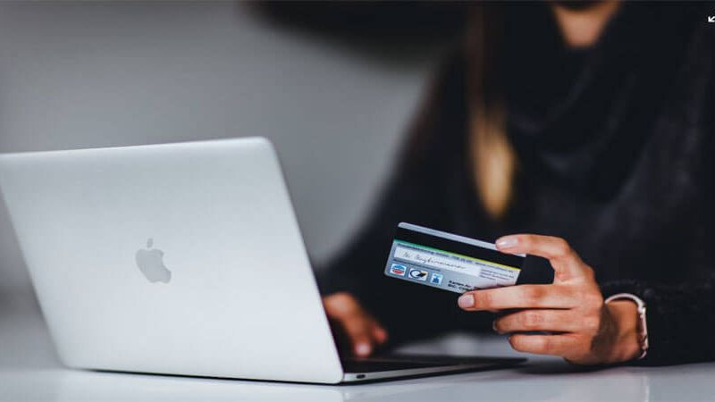 Hình ảnh một người đang nhập thông tin thẻ tín dụng trên máy tính xách tay để hoàn tất quy trình thanh toán cho đơn hàng trực tuyến.