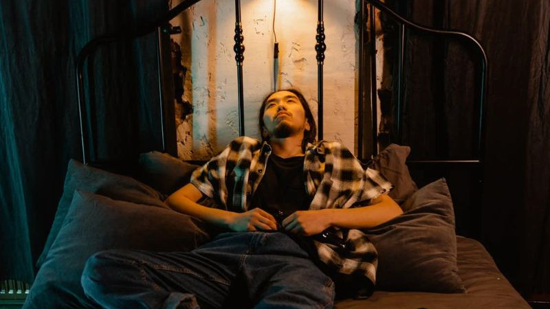 Hình ảnh một người đơn độc trong căn phòng tối, gợi cảm giác bí bách và buồn