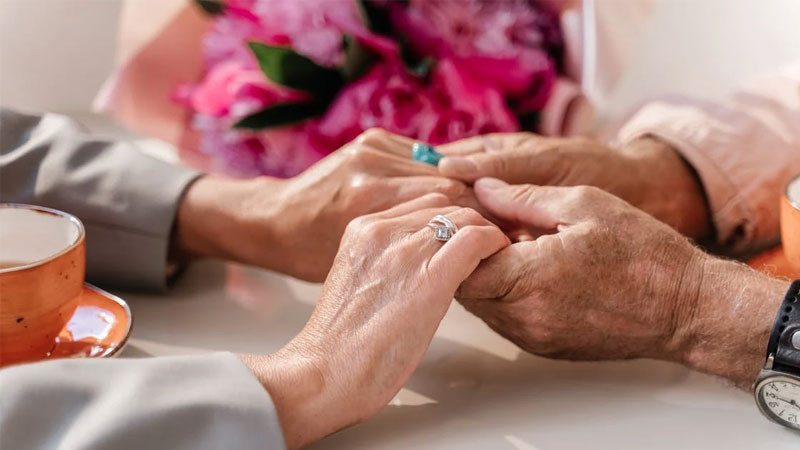 Hình ảnh nắm tay dưới ánh sáng đỏ rực của hoàng hôn trên biển