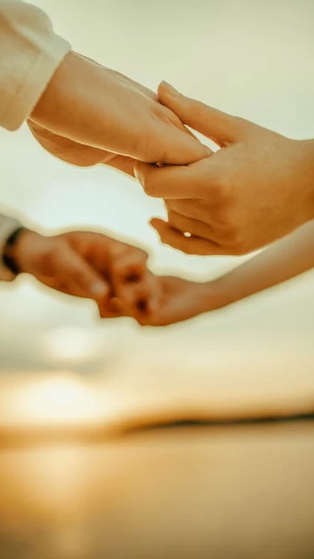 Hình ảnh nắm tay lãng mạn với phông nền là bờ biển và những con sóng nhỏ