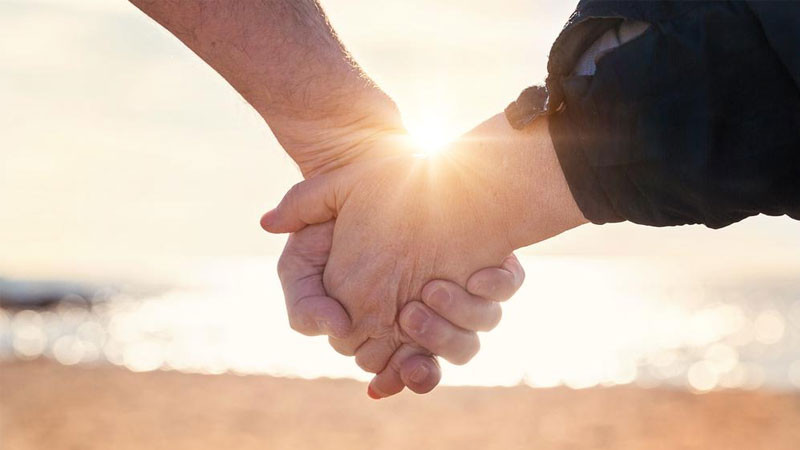 Hình ảnh nắm tay với bối cảnh tường gạch đơn giản