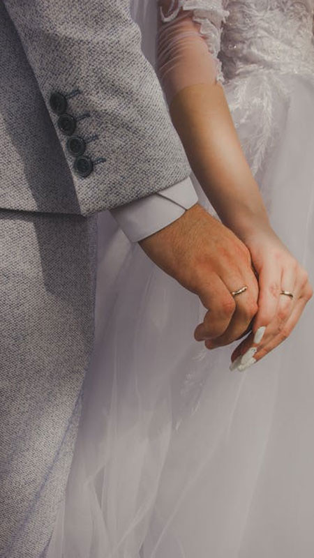 Hình ảnh nắm tay với focus vào chiếc nhẫn, bối cảnh hơi mờ