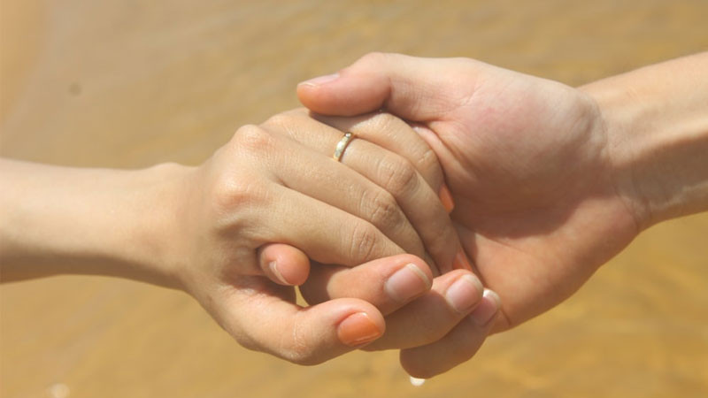 Hình ảnh nắm tay với phông nền màu xanh dương nhạt