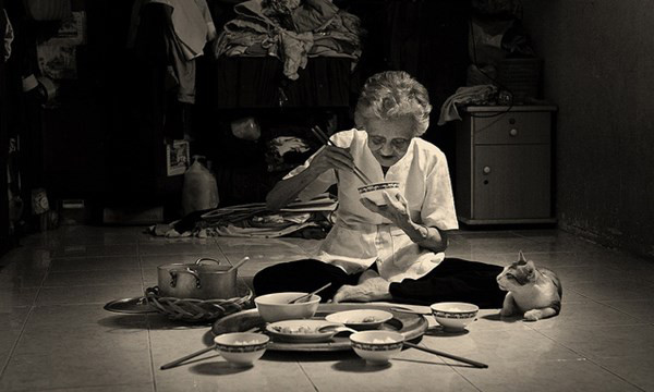 Hình ảnh người bà ngồi lặng lẽ một mình trong gian bếp cũ gợi lên nỗi cô đơn