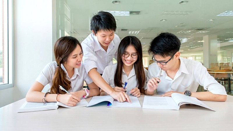 Học sinh ngồi đọc sách tại thư viện với ánh sáng tự nhiên