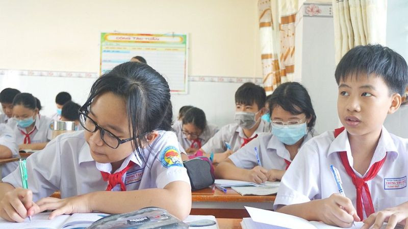 Học sinh ngồi học bài buổi tối với đèn bàn