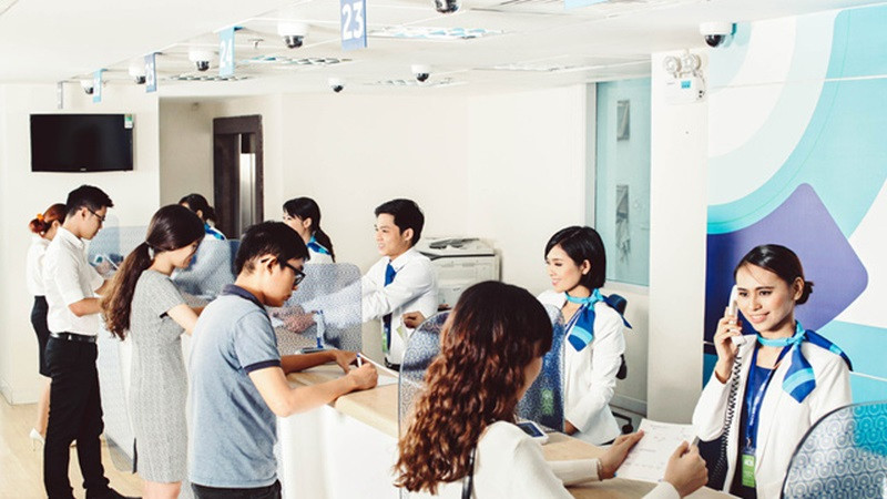 Khách hàng điền đơn đăng ký mở thẻ NAPAS tại quầy giao dịch ngân hàng