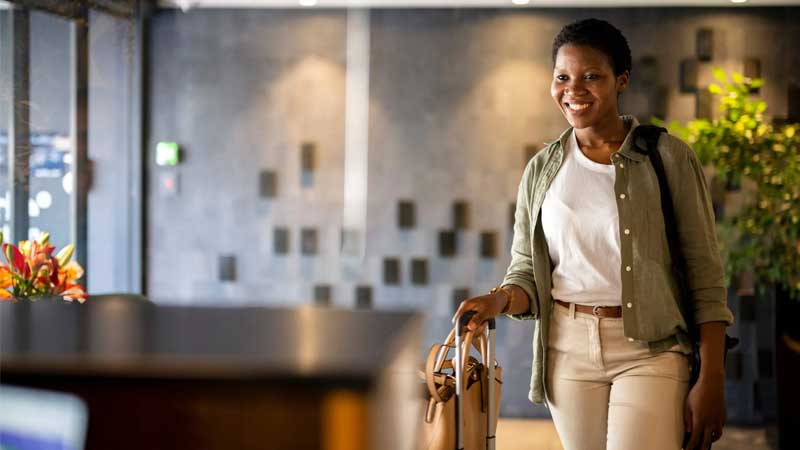 Khách hàng với hành lý trong sảnh khách sạn, liên quan đến giờ check-in và check-out.