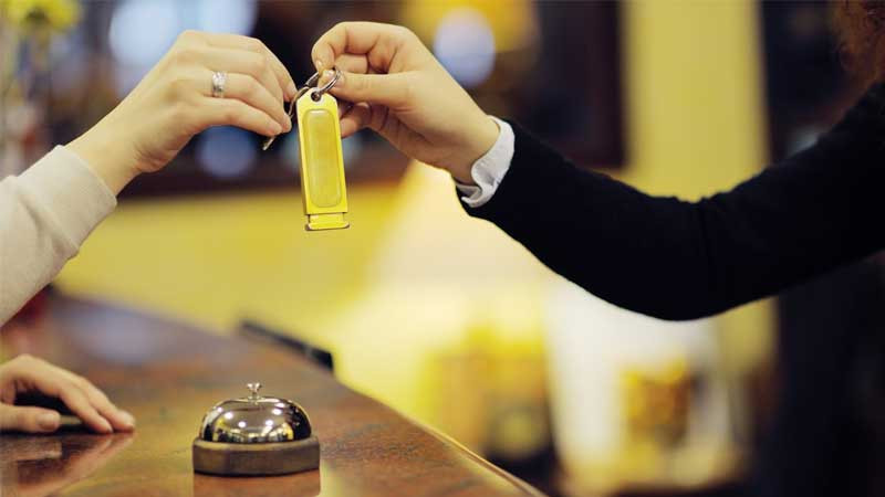 Khách hàng xuất trình giấy tờ tùy thân (hộ chiếu/CCCD) khi làm thủ tục check-in khách sạn.