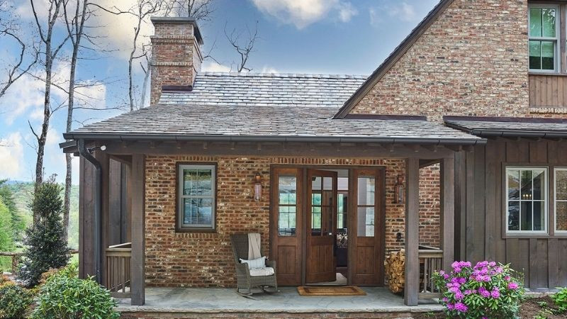 Mặt tiền nhà Rustic với cửa gỗ lớn và đèn lồng