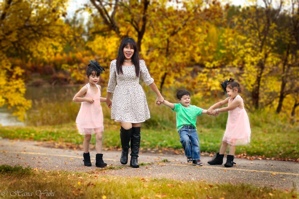 Mẹ dẫn ba con nhỏ đi dạo trên đường