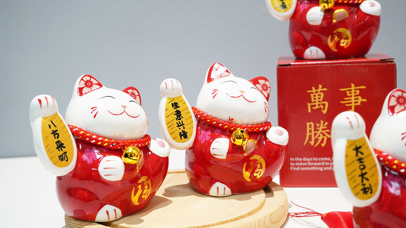 Mèo thần tài với các đồng xu cổ, liên hệ với tài lộc và thành công