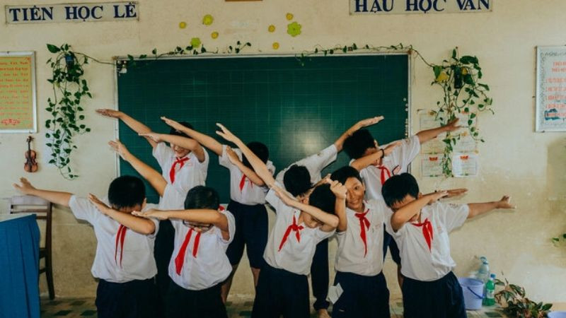 Một góc sân trường với cây xanh và ghế đá