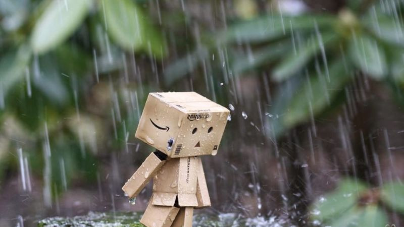 Một người ngồi bên cửa sổ nhìn ra ngoài trời mưa, gương mặt đượm buồn