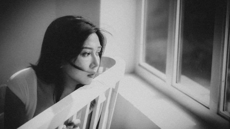 Một người ngồi cô đơn bên góc cửa sổ, nhìn ra không gian ngoài trời